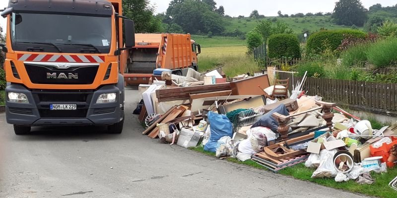 Lkw neben einem Haufen Sperrmüll am Straßenrand