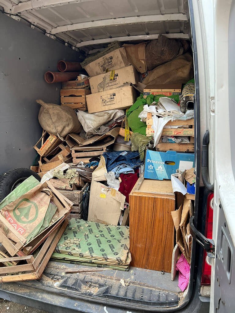 Vollgeladener Transporter mit Kartons, Holzkisten und Sperrmüll