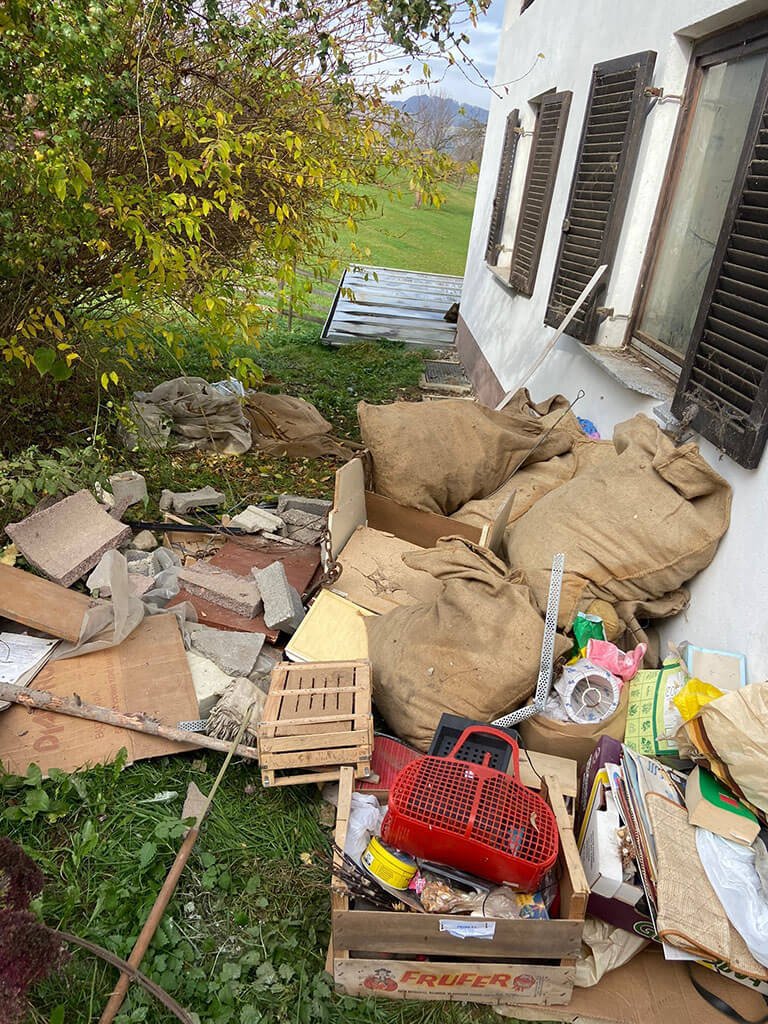 Sperrmüll, Säcke und Kartons im Garten neben einem Haus
